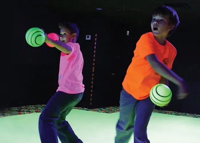 Kids playing blacklight dodgeball at an indoor family fun center in Pittsburgh