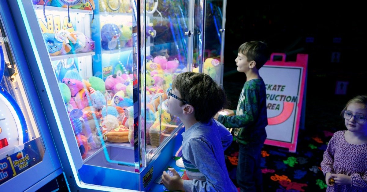 Kids playing arcade games at an indoor entertainment center birthday party