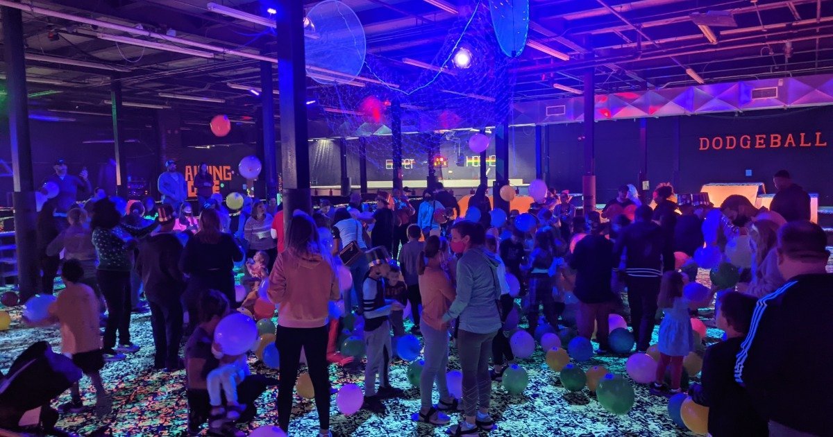 Busy indoor birthday party venue on a weekend with kids celebrating and activities in full swing