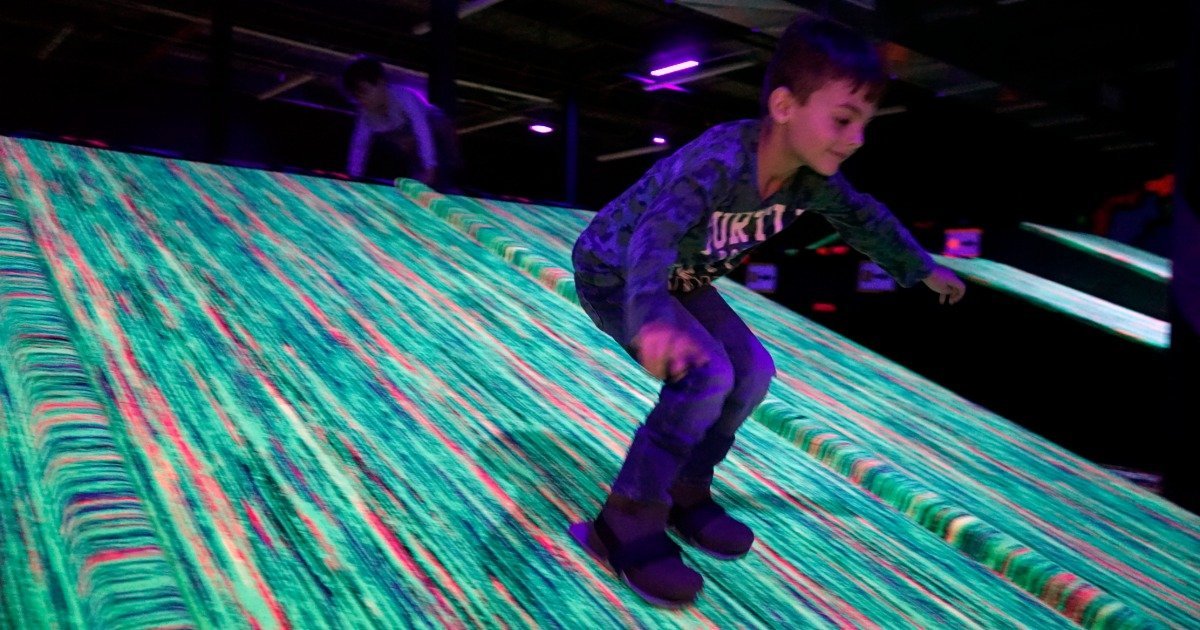 Children carpet skating at an indoor party venue during a birthday party session