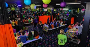 Families skating under blacklights during a group fundraiser night at Fun Slides Carpet Skatepark in Pittsburgh