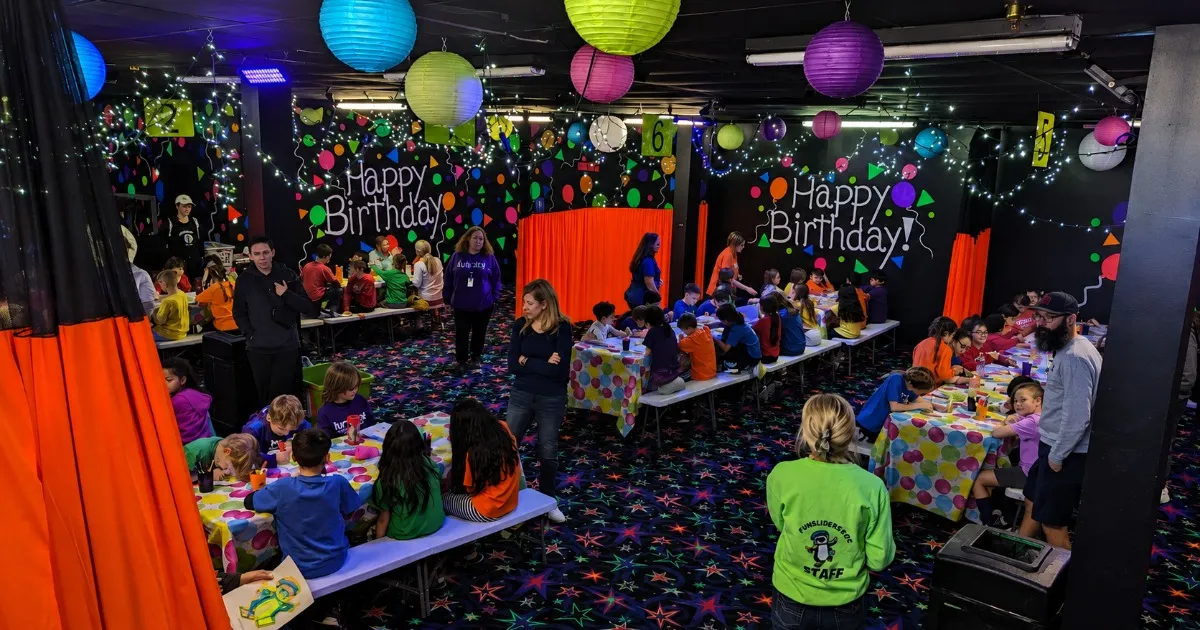 Families skating under blacklights during a group fundraiser night at Fun Slides Carpet Skatepark in Pittsburgh
