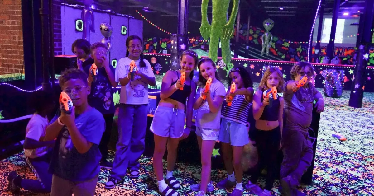 Group of kids laughing together at a blacklight indoor party in Pittsburgh